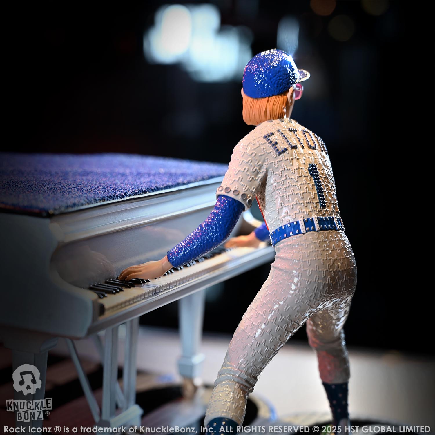 Statue of Elton John with a grand piano in a baseball uniform with a dark background
